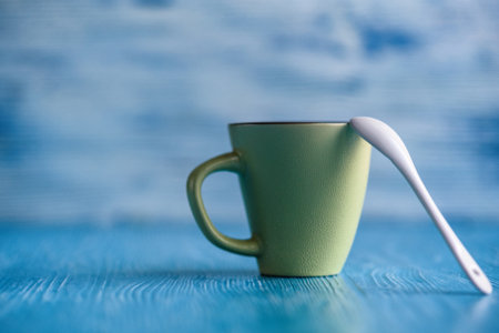Ceramic cup on a wooden background, a spoon is leaning against it.の写真素材