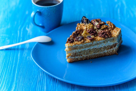 Sponge cake with walnuts, near a cup of coffee.の写真素材