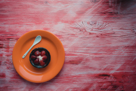 A strawberry cupcake on a plate photographed from the top.の写真素材