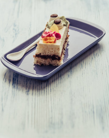 A slice of sponge cake on a rectangular plate.