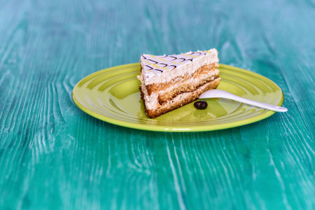 Biscuit cake on a wooden background photographed on a plate in green.の写真素材