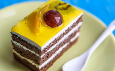 Chocolate puff cake with cherry on top photographed close-up on a wooden background.