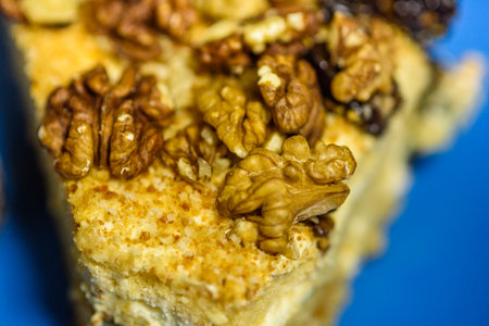 A slice of sponge cake with walnuts close-up.の写真素材