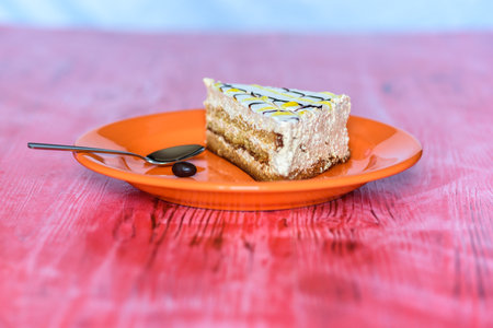 A piece of sponge cake on a plate on a wooden table.の写真素材