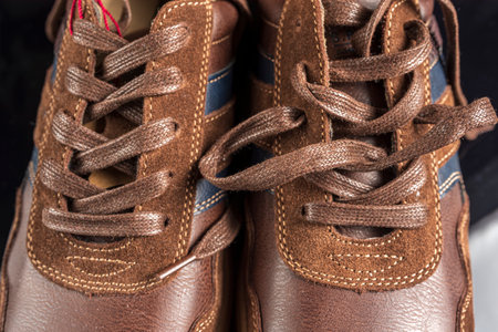 Close up of brown leather shoes with shoelaces on black background