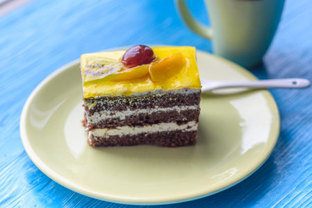 Chocolate puff cake with cherry on top and a cup of coffee photographed close-up on a wooden...