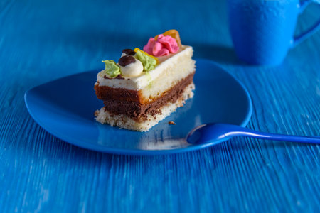 Puff biscuit cake with custard on a ceramic plate, photographed on a blue wooden background.の写真素材