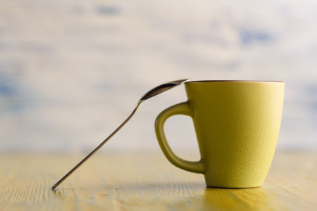 Ceramic cup on a wooden background, a spoon is leaning against it.の写真素材