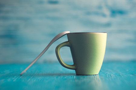 Ceramic cup on a wooden background, a spoon is leaning against it.の写真素材
