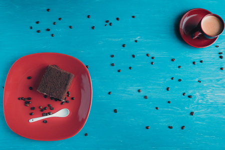 A piece of sponge cake lying on a plate, on a wooden background.の写真素材