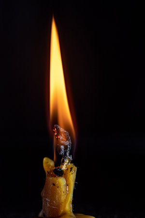 Burning candle on a black background. Close-up image.の写真素材