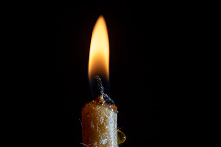 The remainder of the burning candle on a black background.