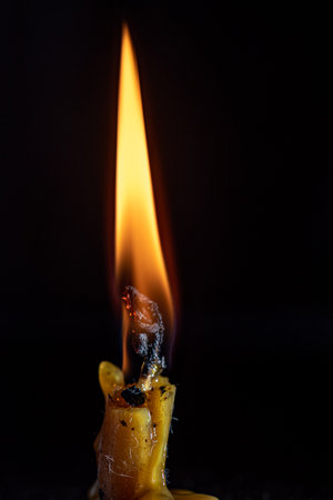 Burning out wax candle on a dark background.の写真素材