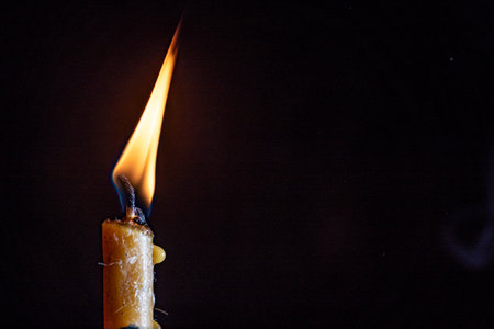 Burning candle on a black background. Shallow depth of field.の写真素材
