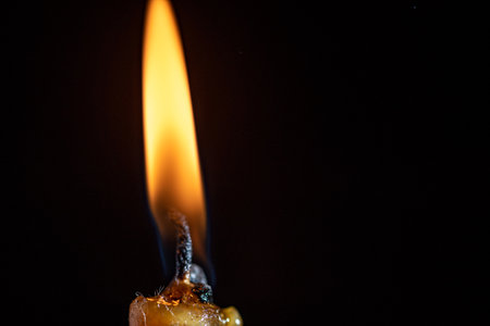 The remainder of the burning candle on a black background.の写真素材