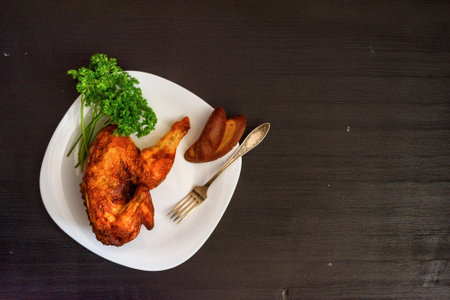 fried chicken on a white plate on a dark wooden backgroundの写真素材