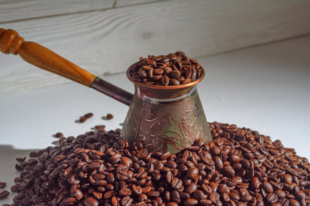 Copper turka with coffee beans on a wooden backgroundの写真素材