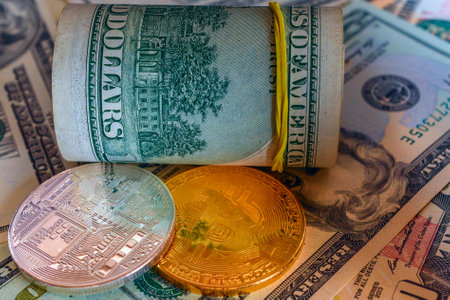 golden and silver bitcoins on the background of dollar bills, close-up