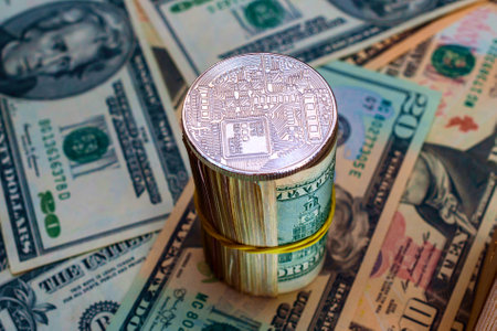 Digital currency physical metal bitcoin coin on the background of dollar bills.の写真素材