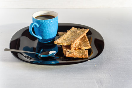 cup of black coffee and cookies on a plate on a background