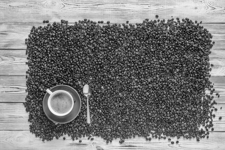a cup of coffee on a background of coffee beansの写真素材
