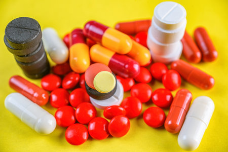 Pills and capsules on a yellow background. Close-up.の写真素材