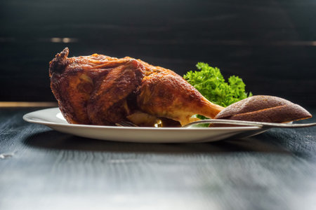 fried chicken on a white plate on a dark wooden backgroundの写真素材
