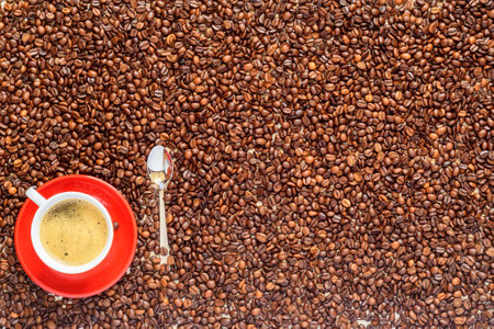 a cup of coffee on a background of coffee beansの写真素材