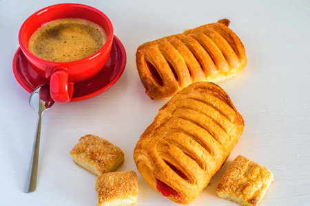 Puff pastry with jam and coffee mug on a white wooden backgroundの写真素材