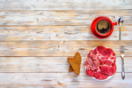 sliced meat on a plate on a wooden backgroundの写真素材