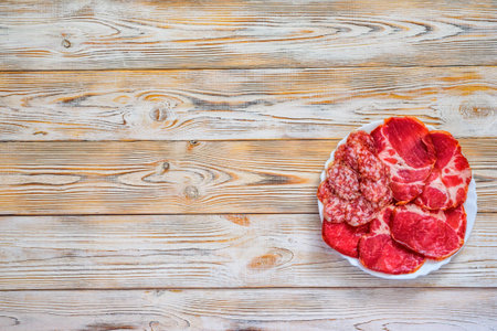 sliced jerky on a plate on a wooden background