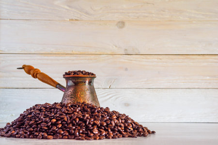 Copper turka with coffee beans on a wooden backgroundの写真素材