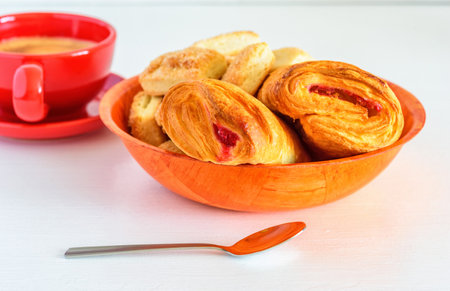 Puff pastry with jam and coffee mug on a white wooden backgroundの写真素材