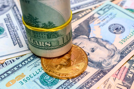 golden bitcoin coin on the background of dollar bills close-upの写真素材