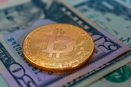 golden bitcoin on the background of one hundred dollar bills close-upの写真素材