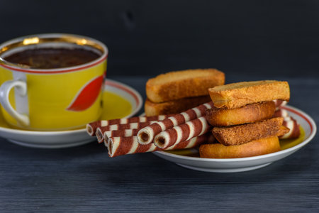 Cup of coffee and cookies on a dark background.