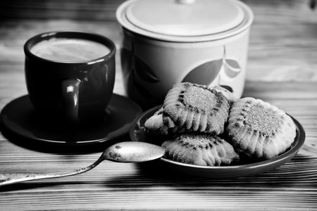 Cup of coffee and cookies on a wooden table. Toned.の写真素材