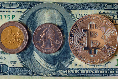 Golden Bitcoin on the background of one hundred dollar bills. Close-up.の写真素材