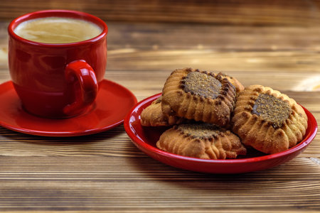 Cup of coffee and cookies with poppy seeds on a wooden tableの写真素材
