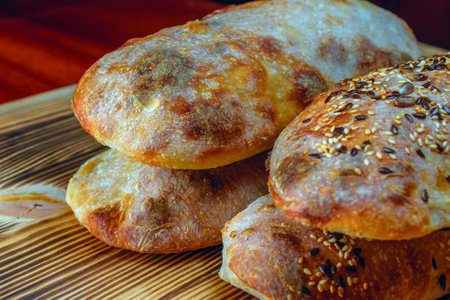 Freshly baked buns with sesame seeds on a wooden boardの写真素材