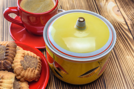 Coffee cup and saucer with cookies on a wooden tableの写真素材