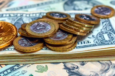 Pile of gold coins on the background of dollar banknotes.の写真素材