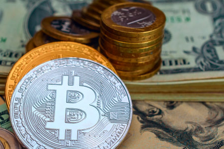 Digital currency physical metal bitcoin coin on the background of dollar bills.の写真素材
