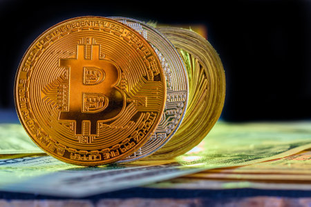 Golden bitcoin on the background of dollar bills. Close-up.の写真素材
