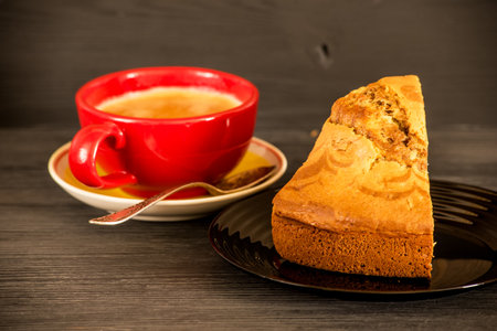 Cup of coffee and piece of cake on wooden background. Toned.の写真素材