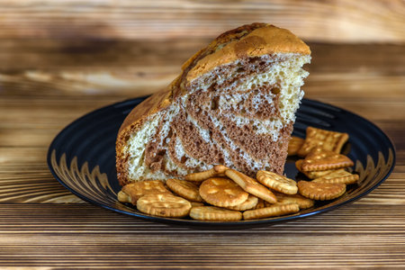Slices of cake and crackers on a plate on wooden backgroundの写真素材