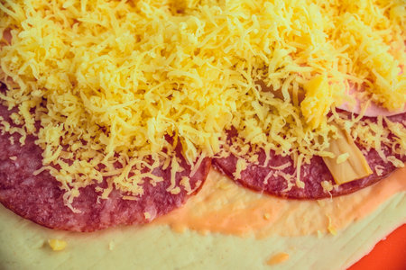 Pizza with cheese and salami on red plate, close up