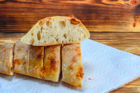 Ciabatta bread on a napkin on a wooden background