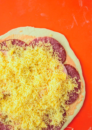 Pizza with salami and cheese on red background.の写真素材