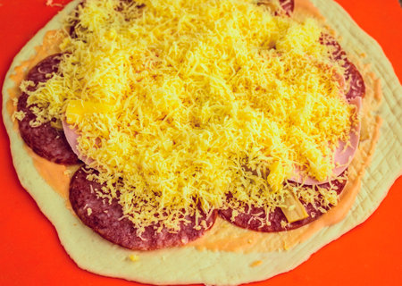 Pizza with cheese and salami on a red background. Toned.の写真素材